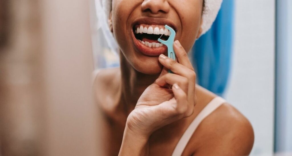 kobieta-czyszcząca-zęby-przed-lustrem